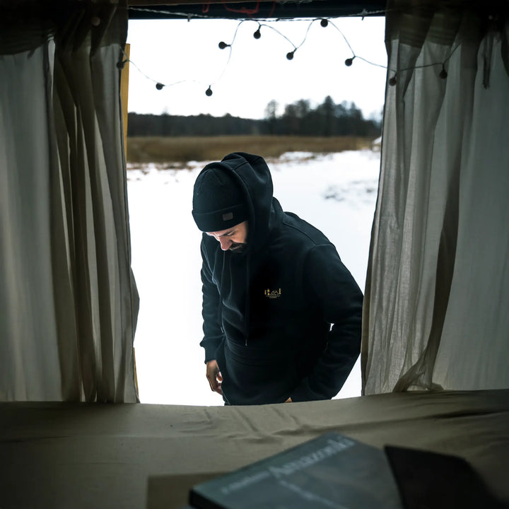 Czarna bluza Wild Fish Stories El Clasico noszona w kamperze, zimowy outdoorowy styl życia podczas postoju w naturze