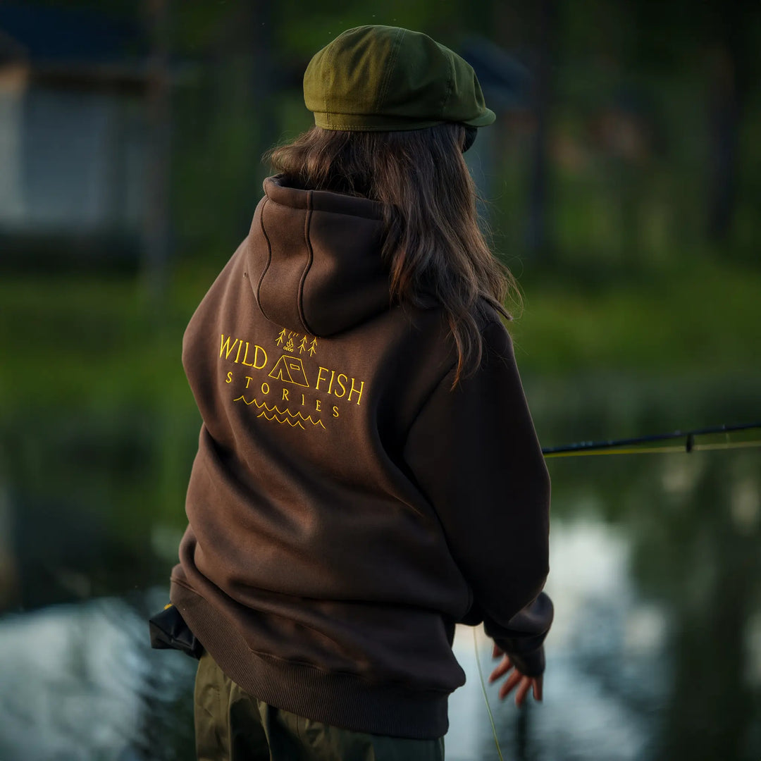 Bluza wędkarska Wild Fish Stories z dużym logo na plecach noszona podczas łowienia nad wodą, outdoorowy styl życia