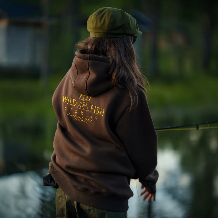 Bluza wędkarska Wild Fish Stories z dużym logo na plecach noszona podczas łowienia nad wodą, outdoorowy styl życia