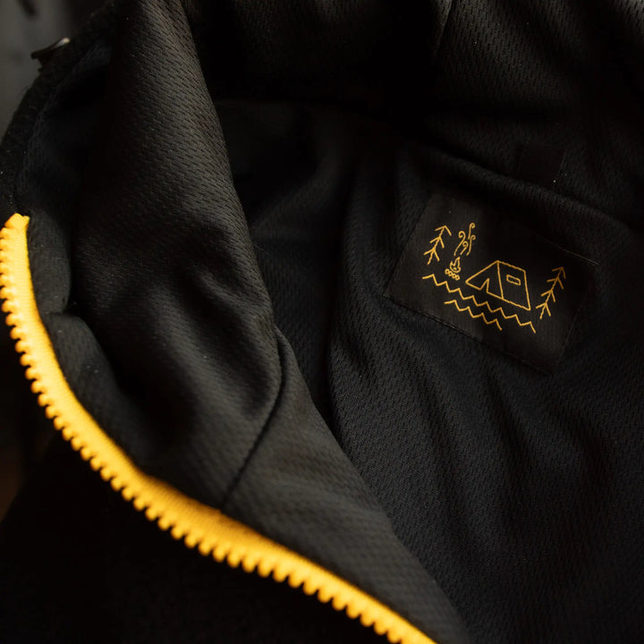 Detal polara Black Bear Wild Fish Stories – struktura podszewki polaru, kontrastowy zamek i haftowane logo outdoor